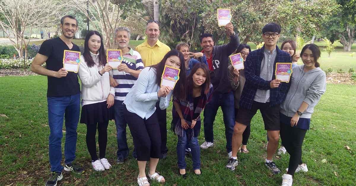 Amigos tomas viajar grupo de compañeros posando para cámara con un título en la mano